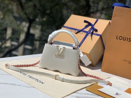 size 22x14x7.5cm 
The M22121 white mini Capucines Capushell MM handbag is designed with a wavy bottom to rejuvenate the Capucines. The Taurillon leather is heated by hot pressing process. After molding and cooling, it achieves a flexible shape like a shell. It is delivered from the factory and you will get what you get for a penny. You will definitely be satisfied!